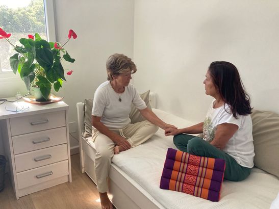 Un hombre está acostado en una mesa recibiendo un masaje de una mujer.